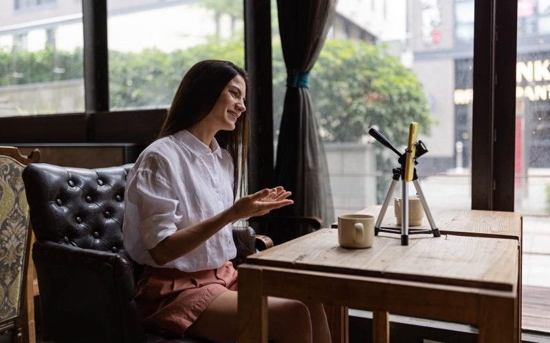 happy-young-caucasian-woman-influencer-using-technology-in-cafeteria-or-studio.jpg